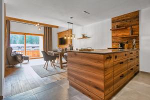 a kitchen with a large wooden counter and a dining room at Chalet Loferwinkl in Reit im Winkl