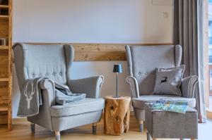 two chairs in a living room with a table and a lamp at Chalet Loferwinkl in Reit im Winkl