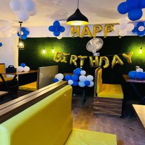 a restaurant with a happy birthday sign and blue balloons at Hotel The Galaxy in Dabok