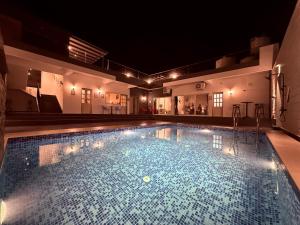 a swimming pool at night with lights on it at Casa Oceanus - Pool View Room - Ganpatipule in Nevra