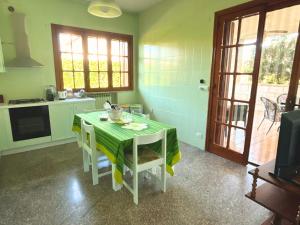 a kitchen with a table with a green table cloth at Casa Vacanze Villa Chiara in San Vito
