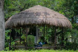 a gazebo with a straw roof at Hotel Monalisa Chitwan in Chitwan