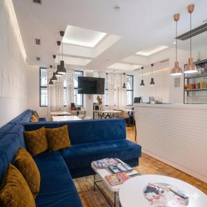 ein Wohnzimmer mit einem blauen Sofa und einem Tisch in der Unterkunft Hotel Passport in Belgrad