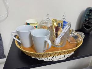 a tray with cups and other items on a shelf at ANA Apartment in Hail
