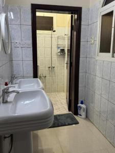 a white bathroom with a sink and a shower at ANA Apartment in Hail +18 photos