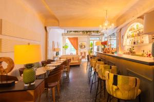 a restaurant with a bar with yellow chairs and tables at Abalú Collection Hotel Boutique Gran Via in Madrid