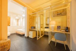 a room with a bedroom with a desk and a bed at Abalú Collection Hotel Boutique Gran Via in Madrid +82 photos