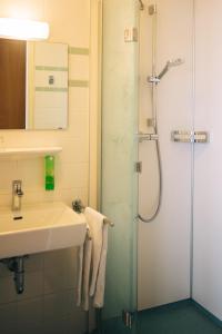 a bathroom with a sink and a shower at Bildungshaus St. Hippolyt in Sankt Pölten +24 photos