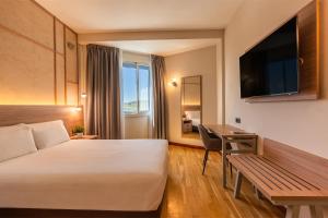 a hotel room with a bed and a desk at Spirit Hotel Ciudad de Burgos in Rubena
