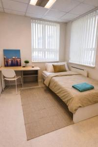 a bedroom with a bed and a desk and windows at Hobeda 6 Guest House in Tallinn