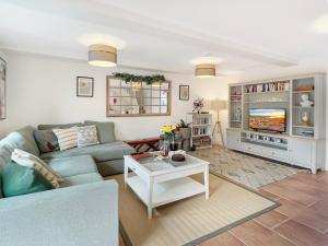 a living room with a couch and a tv at The Stables Lydeard St Lawrence in Combe Florey