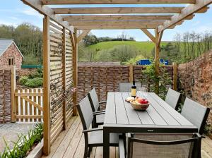 a wooden table and chairs on a wooden deck at The Stables Lydeard St Lawrence in Combe Florey