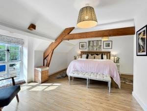 a bedroom with a bed and a large window at The Stables Lydeard St Lawrence in Combe Florey