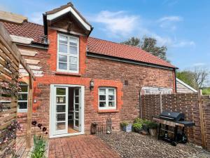 a red brick house with a grill in front of it at The Stables Lydeard St Lawrence in Combe Florey