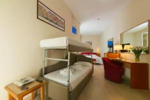 a small room with a bunk bed and a desk at Hotel Kursaal in Rimini +60 photos