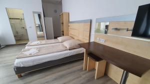 a bedroom with a bed and a desk and a television at Hotel Moji 5 Solingen in Solingen +4 photos