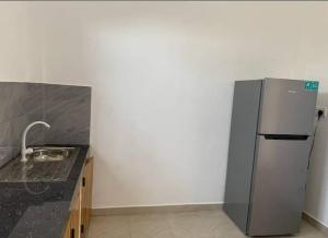 a kitchen with a refrigerator and a black counter top at Ceylon Seaway Villa in Trincomalee