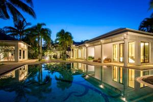 a villa with a swimming pool at night at The Anda Mani Khaolak Beachfront Villas - Adult only in Khao Lak