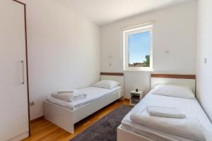 a bedroom with two beds and a window at My Nest Accommodation in Privlaka +34 photos