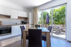 a kitchen and dining room with a table and chairs at My Nest Accommodation in Privlaka