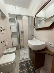 a bathroom with a sink and a toilet and a mirror at Il Vicoletto in Biccari