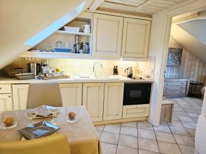 a kitchen with white cabinets and a table and a sink at L'Escale au Lac - Vue panoramique - parking & plage privés in Duingt
