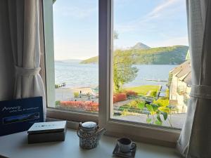 a window with a view of a body of water at L'Escale au Lac - Vue panoramique - parking & plage privés in Duingt