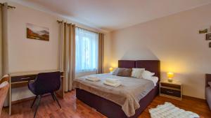 a bedroom with a bed and a chair and a window at W Samiuśkim Centrum in Szczyrk