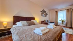 a bedroom with a large bed with towels on it at W Samiuśkim Centrum in Szczyrk