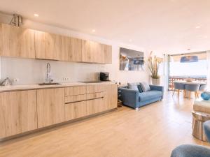 a kitchen and living room with a couch and a table at RenTenerife Elim Ocean in La Tejita