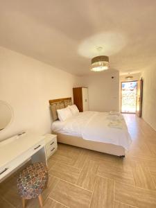 a bedroom with a large white bed and a table at kastro konak in Gokceada Town