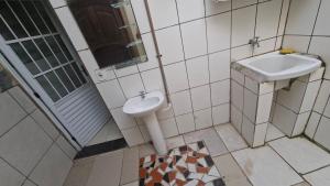 a bathroom with a sink and a toilet at Casa 2 minutos a pé da Praia de INDAIÁ in Bertioga