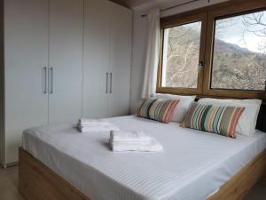 a bedroom with a large bed with towels on it at Forest and Sea view villas in Samothraki