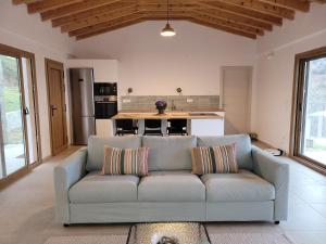 a living room with a couch and a kitchen at Forest and Sea view villas in Samothraki