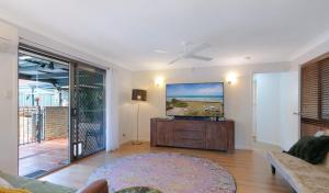a living room with a couch and a ceiling fan at Spacious home with pool in Kippa-Ring in Newport