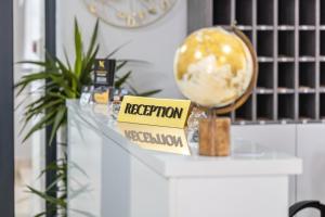 a desk with a reception sign and a globe on it at Hotel Mondo in Budva