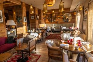a restaurant with tables and chairs in a room at Hotel Le V de Vaujany in Vaujany