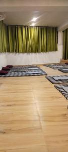 a room with green curtains and a wooden floor at Himalayan siddh yog ashram in Rishīkesh