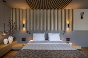 a bedroom with a large bed with two white pillows at Golden Age Athens Hotel in Athens +71 photos