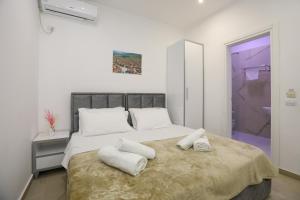 a bedroom with a large bed with towels on it at Hotel SUNSET GL in Vlorë
