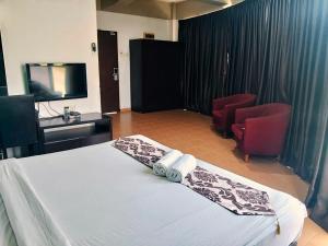 a hotel room with a bed and a tv at Hotel Sayang in Kulai