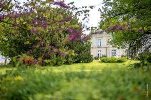 an image of a house with flowers in the yard at Domaine Beaumont - Vignoble & Maison d'Hôtes Vigneronne in Distré