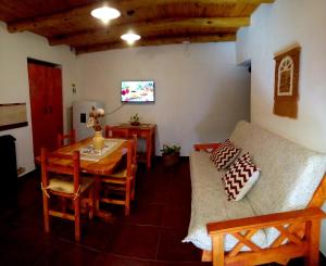 a living room with a table and a couch at Cabañas Flor De Lis in Valle Hermoso