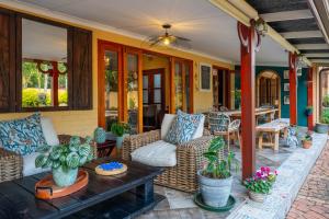 a porch with couches and a table and plants at Hampton House Guest House in Centurion