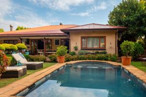 a house with a swimming pool in front of a house at Hampton House Guest House in Centurion