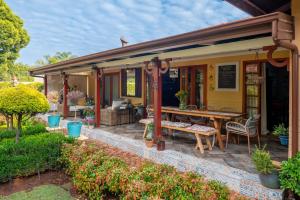 a small yellow house with a table and chairs at Hampton House Guest House in Centurion