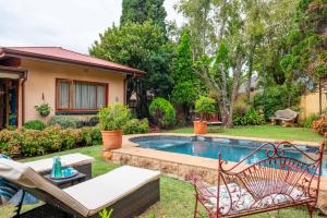 a backyard with a swimming pool and a house at Hampton House Guest House in Centurion +36 photos