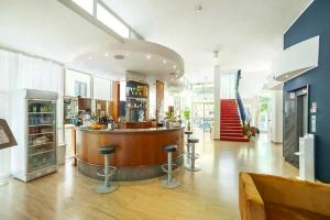 a restaurant with a bar with stools in a room at Hotel Kursaal in Rimini
