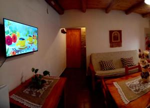 a living room with a flat screen tv on the wall at Cabañas Flor De Lis in Valle Hermoso