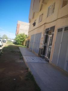 an empty sidewalk next to a building with gates at Zerarda in Saïss